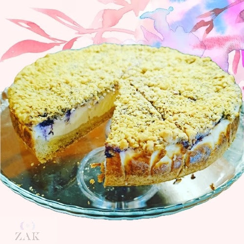 Cheescake crumble con arandanos Sumérgete en la serena indulgencia de nuestra tarta de queso crumble con arandonos de ZAK es una tarta de queso con una cubierta crumble. Cheescake crumble con arandanos